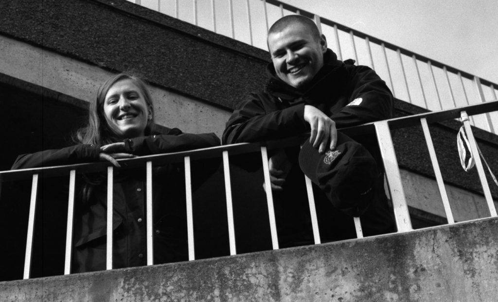 Alex Porter-Smith and Eathan Currie smiling and leaning on a railing